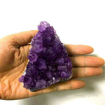 Fragment de druse d'améthyste dans la main, vendu au poids 10 à 20 g — VoxArcana